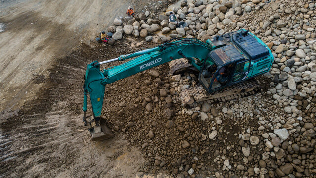 Kobelco Excavator and Workers in Rock and Sand Quarry, Mining Site from Above on May 25, 2026 in Purwokerto, Central Java, Indonesia 