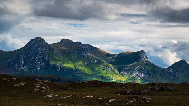Mont Ben Loyal sous un jeu d'ombre et lumi&egrave;re dans les Highlands &eacute;cossaises sous un ciel nuageux, route NC 500, Ecosse