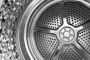 Reflective perforated metal surface inside a contemporary washing machine drum