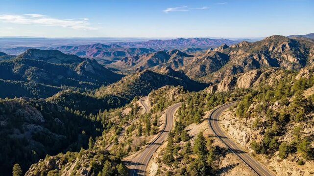 Winding mountain road through a scenic landscape, dramatic travel view for adventure, road trip, transport and nature themes, curving asphalt, layered hills, expansive horizon, crisp daylight,