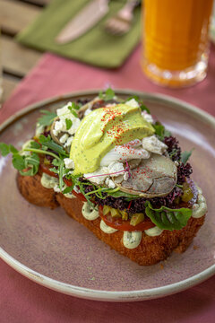 Gourmet avocado toast with sliced horse meat fresh greens and creamy sauce served for stylish brunch