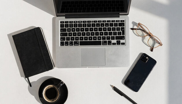 Overhead view of laptop notebook and mobile phone on a white surface