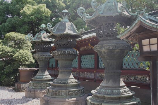 Three massive traditional Japanese stone lanterns (Ishi-doro) standing in Ueno.