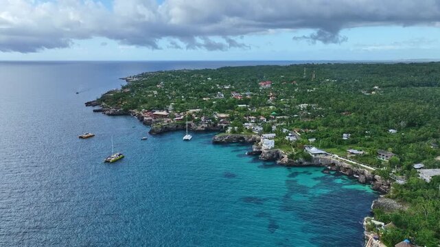 drone shot of sea with boats and land in Negril west end.