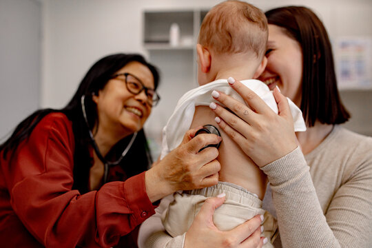 Healthcare professional examining infant in clinic room