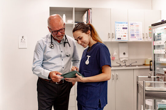 Doctor and nurse reviewing information on a tablet while waiting for patient in the clinic