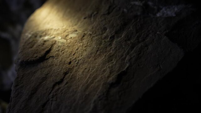 Light revealing mineral vein across rock surface with cinematic texture