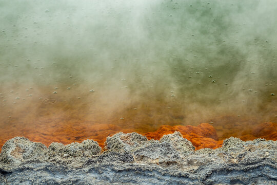 Bubbles, steam, orange mineral precipitate, and green water in Champagne Pool