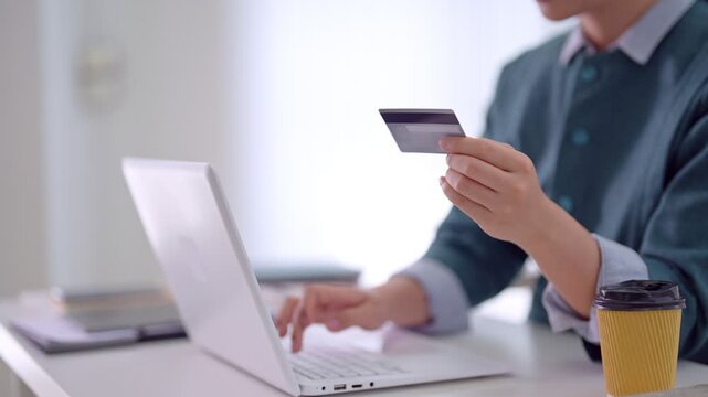Asian business women hold credit card laptop computer online shopping ecommerce payment transaction home office desk modern workspace casual clothing concept