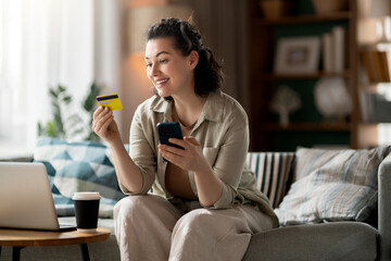 Obraz premium Happy Woman Shopping Online with Credit Card and Smartphone at H
