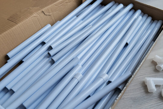 Metal tubes for a clothes rack are packed in a cardboard box, representing flat pack furniture delivery and DIY assembly at home