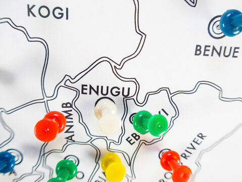 A close-up of a white map showing Nigerian states from colorful pushpins&mdash;white, green, blue, red, and yellow&mdash;mark states including Enugu, Ebonyi, Kogi, and Benue.
