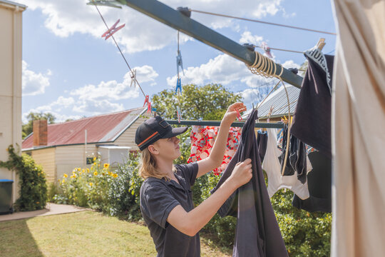 Teenager taking down the laundry from the washing line