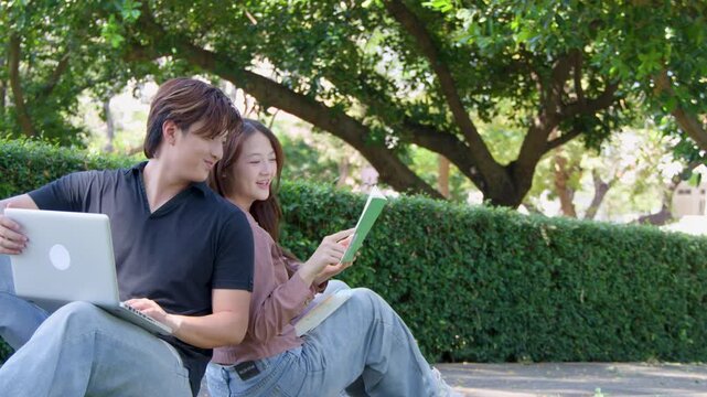 Thai University Students Studying Together with Laptop and Book in Campus Park