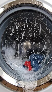 Washing machine drum with water and clothes.