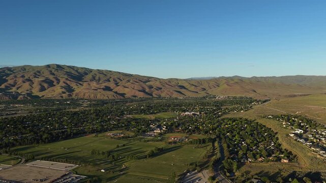 Wide aerial of southeast Boise Idaho neighborhoods and foothills at sunset in spring
