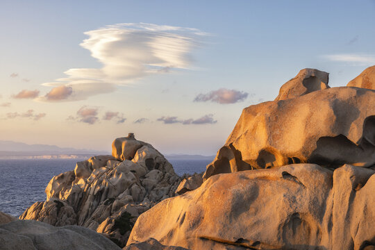 View of the unique granite rock formations of Capo Testa at sunset with the Mediterranean Sea and lenticular clouds in the background Capo Testa, Sardegna, Italy.