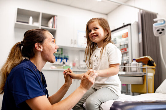 Female healthcare professional cheering up a child in clinic