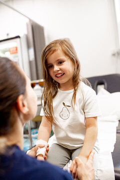 Child with bandaged hand supported by healthcare professional