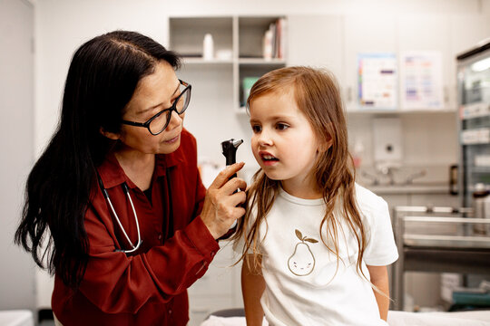 Medical practitioner providing attentive paediatric ear examination