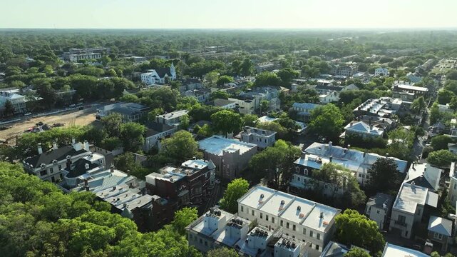 Aerial drone view of Savannah's South Historic District in Georgia, showcasing rows of colorful historic homes, tree-canopied streets, and timeless Southern charm.