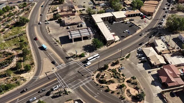 4K static timelapse captures busy morning rush hour traffic flowing through a Santa Fe, New Mexico intersection. Cinematic urban footage reveals fast-moving commuter vehicles on two multi-lane streets