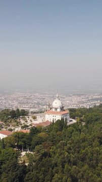 Vertical aerial circling view of the Sanctuary of Our Lady of Sameiro and surrounding landscape in Braga, Portugal.