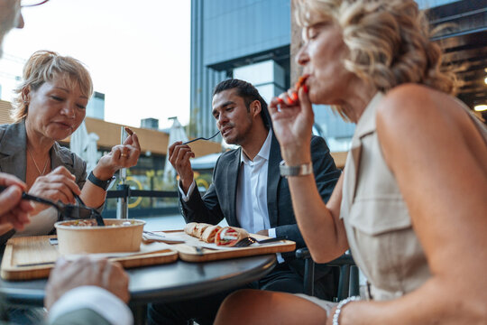 Diverse business professionals sharing outdoor lunch break