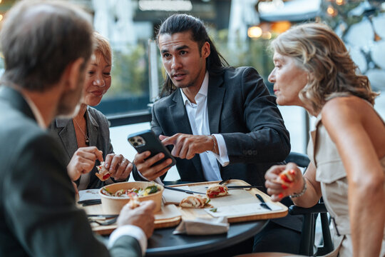 Business people having lunch meeting discussing ideas outdoors