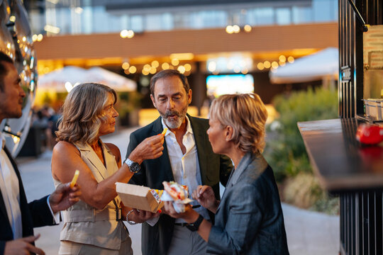 Business colleagues enjoying street food after work