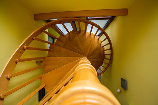 View of a wooden spiral staircase with yellow walls and indoor architectural details in Sremska Mitrovica, Vojvodina, Serbia.