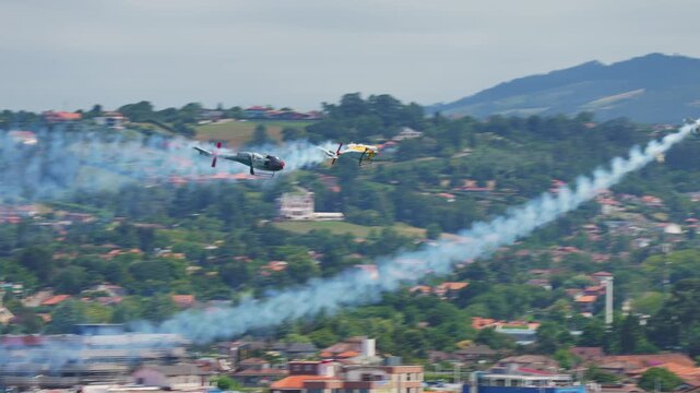 GIJON, SPAIN - JULY 27, 2025: Spanish Air Force Patrulla ASPA formation of three EC120 Colibri helicopters flying with smoke trails over Gijon coastline
