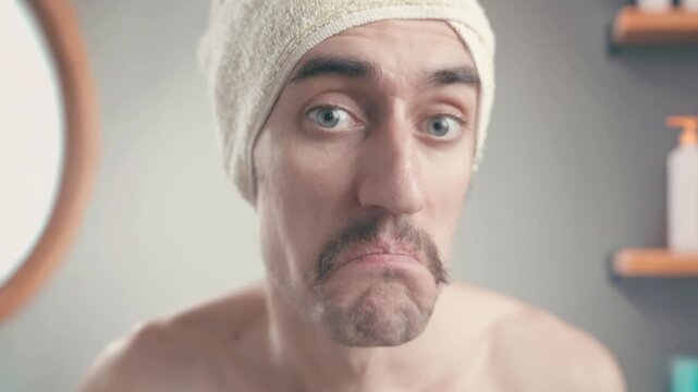 Confused mustached man in bathroom with towel on head shrugging, unsure and doubtful, shifting to surprise and enthusiasm