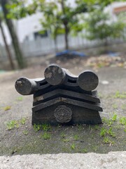 Fototapeta premium Ancient Japanese Decorative Roof Ridge Tile with Floral Crest on Ground