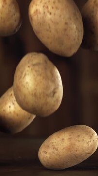Fresh potatoes fall on the table. Filmed on a high-speed camera at 1000 fps. High quality FullHD footage