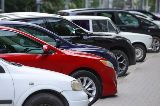 Row of parked cars in a city street parking lot.