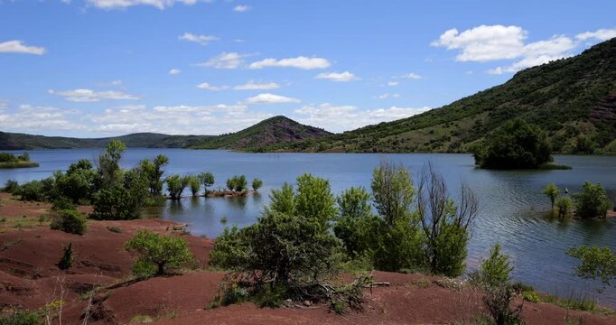 Red landscape surrounding te artificial lake of Salagou, Occitania, Southern France.
