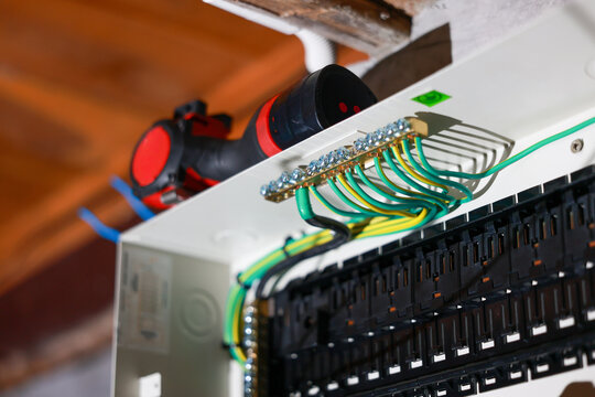 Close macro view of electrical panel wiring showing ground wire safety connection inside breaker box circuit board ensuring secure and reliable power distribution during maintenance work