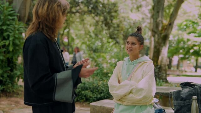 Two women engage in supportive outdoor discussion in city park