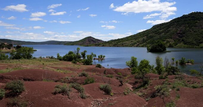 Red landscape surrounding te artificial lake of Salagou, Occitania, Southern France.