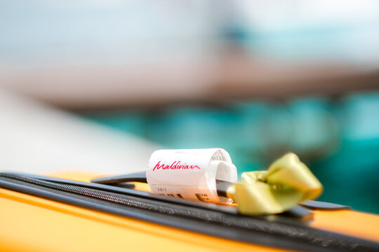 02.05.25, Male, Maldives - Sign "Maldivian" in red, resting on a yellow luggage bag in a tropical hotel setting, conveying relaxation and travel. , Beach escape, luxury travel