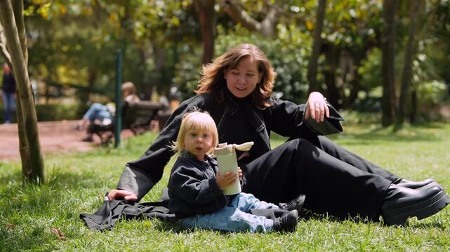 Parents bonding during casual outdoor picnic with child and greenery