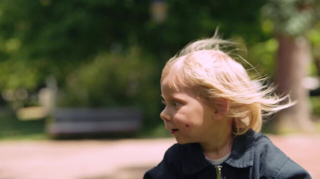 Toddler kneels and scrutinizes miniature elements with great attention