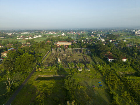 Aerial view of Plaosan Kidul Temple complex with ancient stone ruins surrounded by lush green vegetation and rural houses Kecamatan Prambanan, Jawa Tengah, Indonesia.