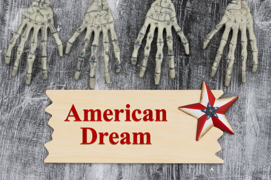 American Dream text with two pairs of skeleton hands on with a sign and USA flag star on weathered wood