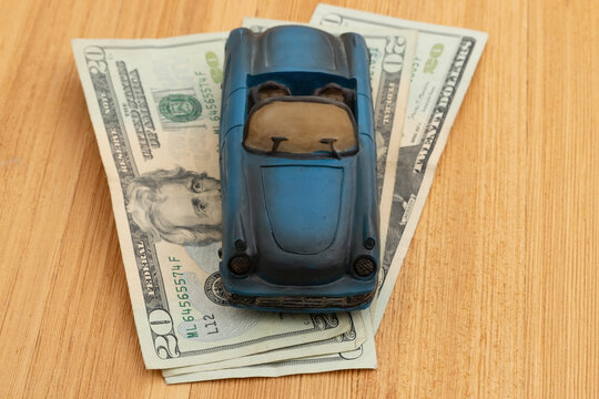 Car on money on wood desk