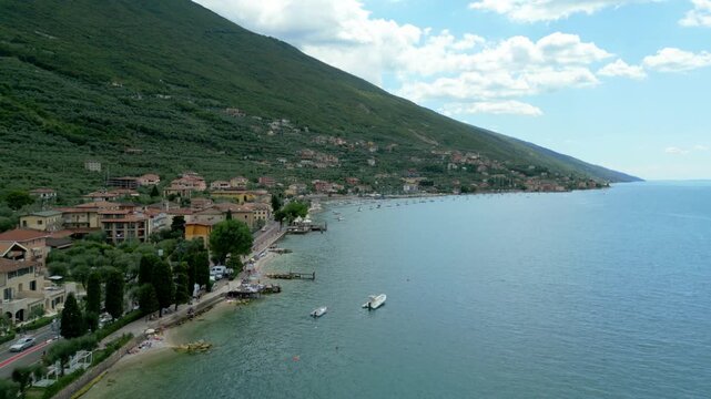 Aerial view of Malcesine waterfront, lakeside village, boats and Monte Baldo slope
