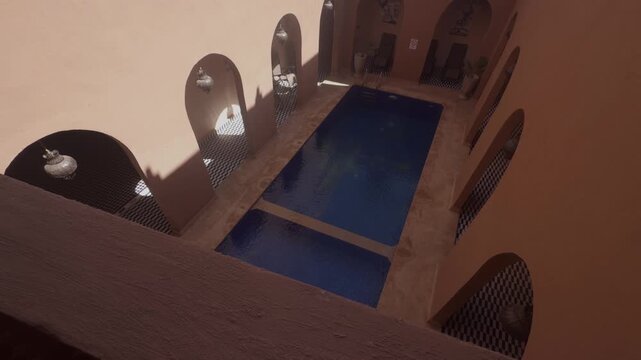 Overhead view of a Moroccan riad spa courtyard with two blue pools surrounded by arched alcoves and pottery