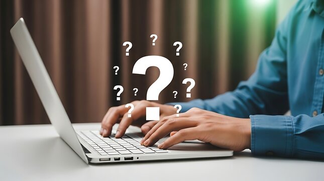 Person typing on laptop with white question marks floating above keyboard hands