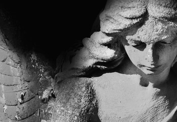 Obraz premium Sad angel statue in dramatic black and white composition.